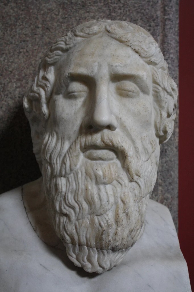 Close-up view of a marble bust depicting an ancient philosopher with a detailed beard and facial features.